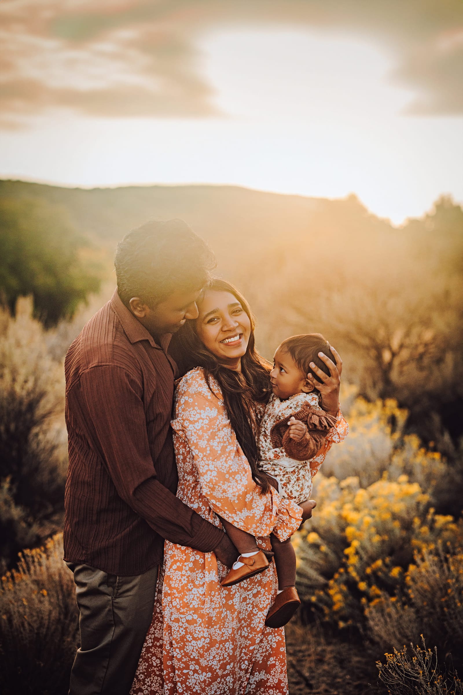 Parents holding their young child in glowing Tri-Cities evening light