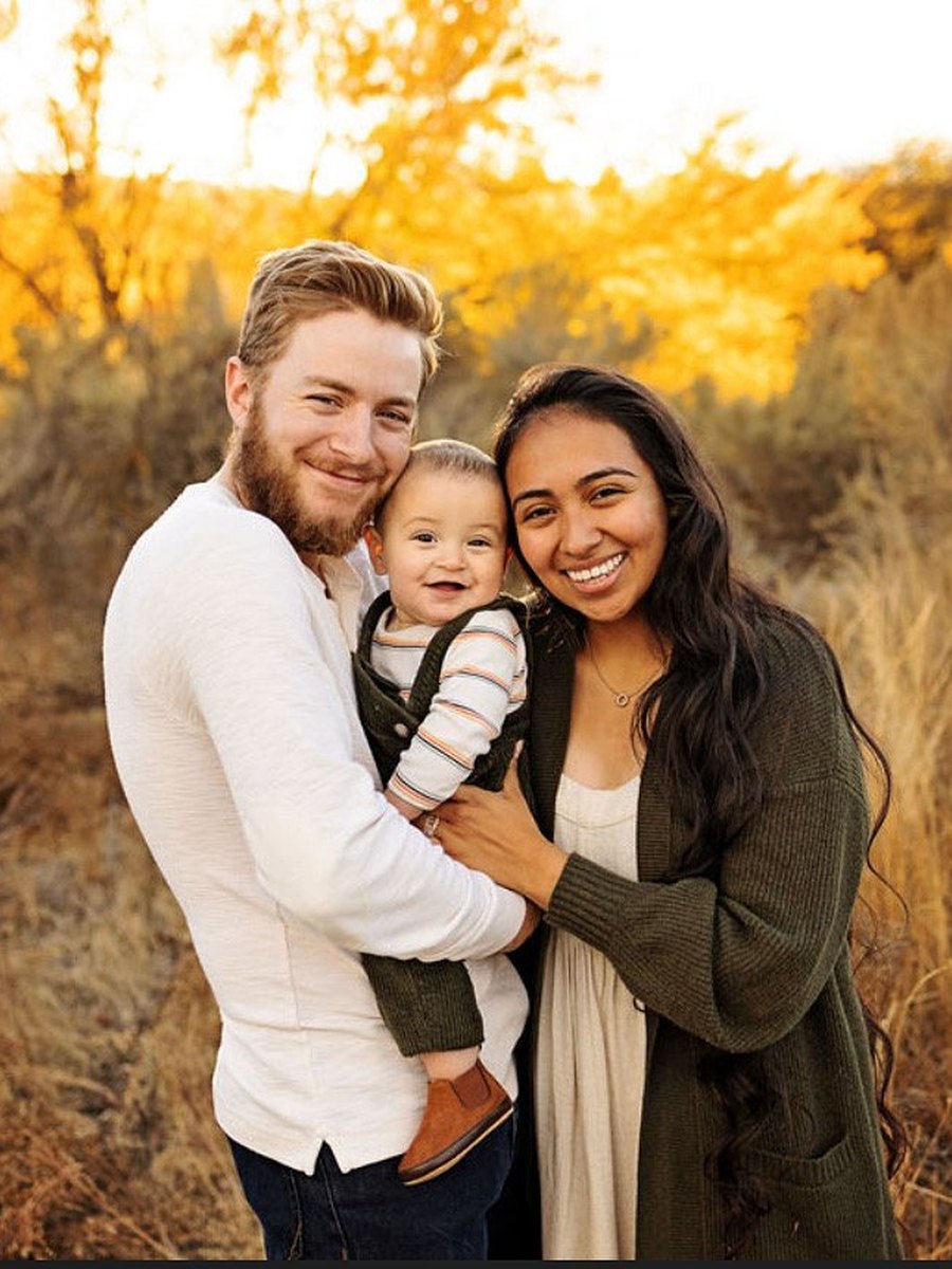 A couple holding their baby close in golden autumn light near Richland