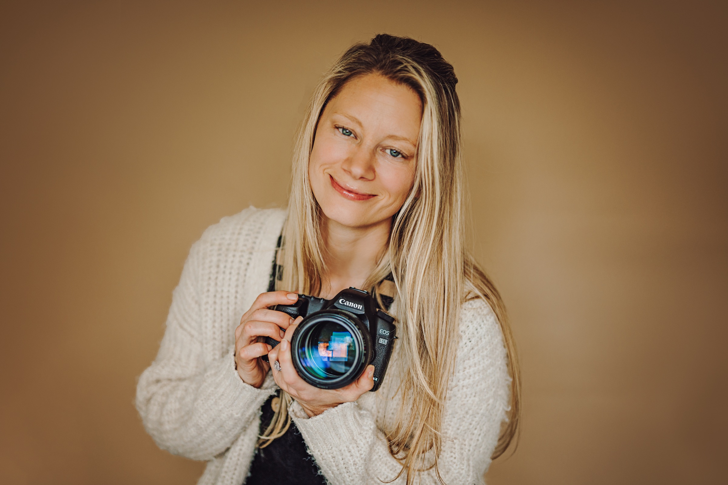 Lisa Weiss holding her camera in her Richland photography studio.