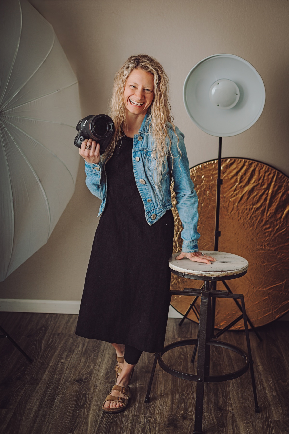 Lisa Weiss smiling with her camera in her Richland studio.