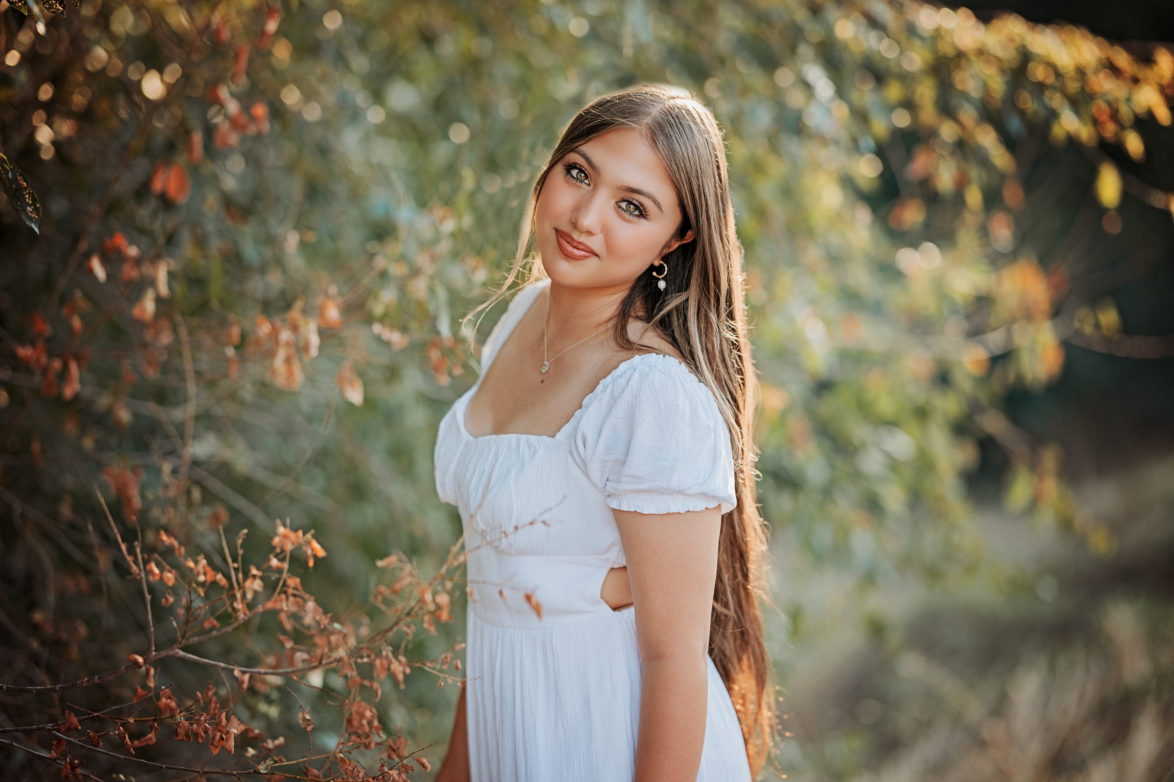 Senior photographed in soft natural greenery during a Tri-Cities portrait session