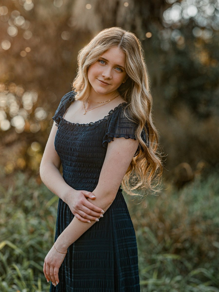 High school senior in a black dress photographed at golden hour in Richland