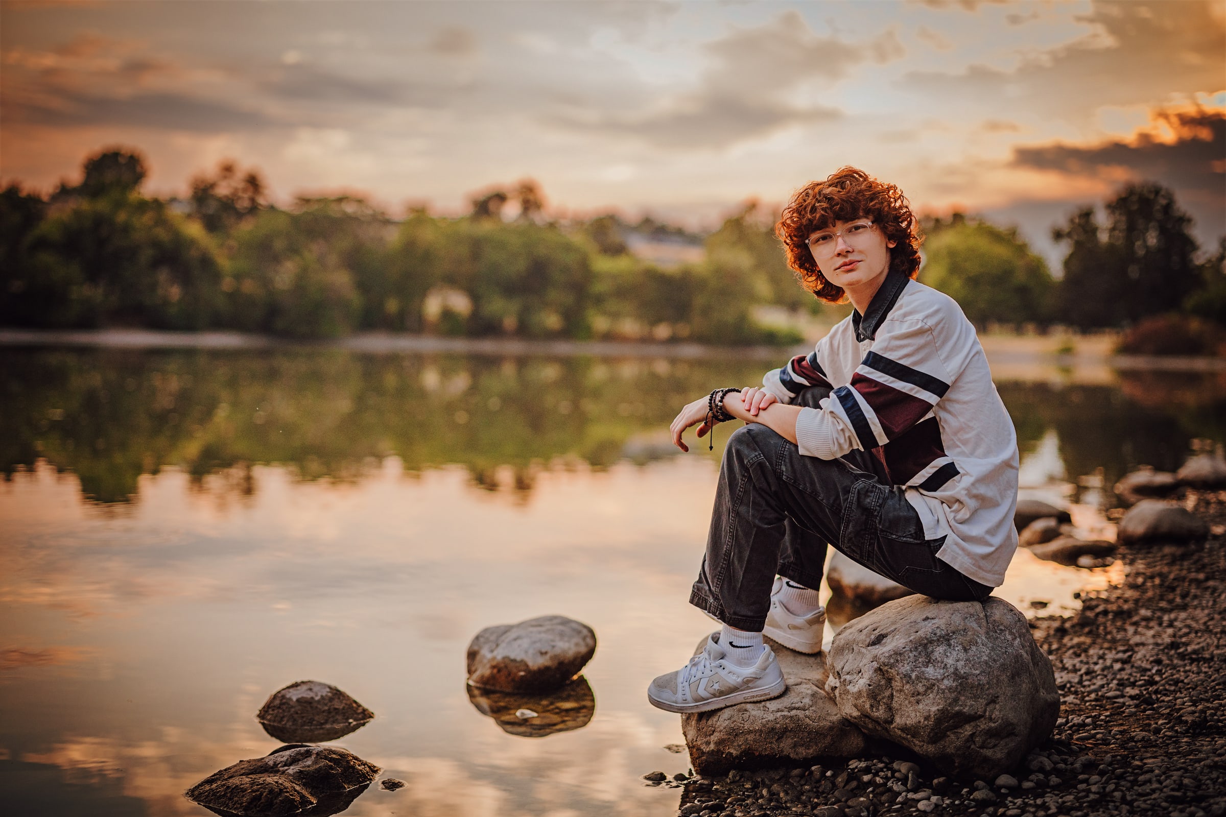 High school senior photographed beside the river at golden hour in the Tri-Cities