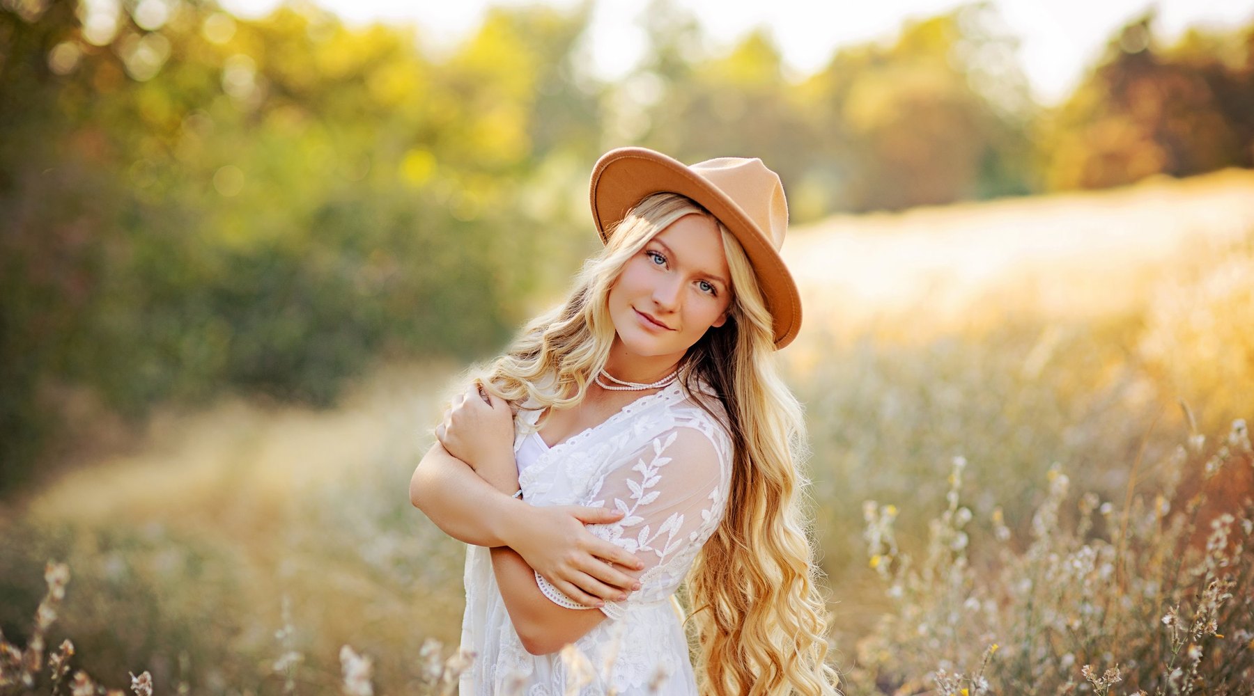 A senior standing in a sunlit Tri-Cities field near the end of the day